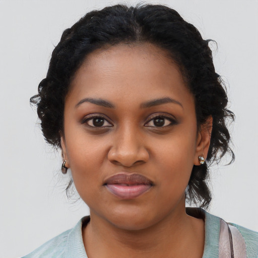 Joyful black young-adult female with long  black hair and brown eyes