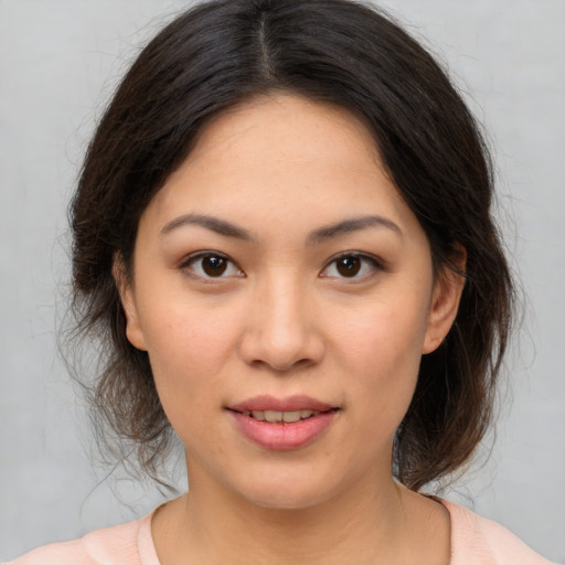 Joyful asian young-adult female with medium  brown hair and brown eyes
