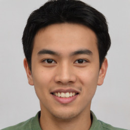 Joyful asian young-adult male with short  black hair and brown eyes