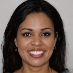 Joyful black young-adult female with long  brown hair and brown eyes