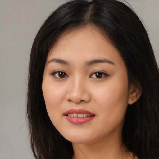 Joyful asian young-adult female with long  brown hair and brown eyes
