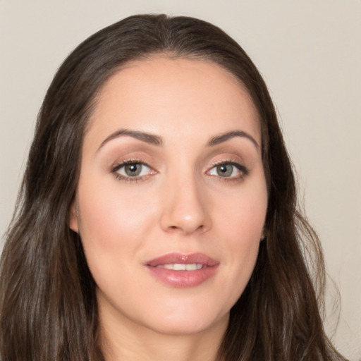 Joyful white young-adult female with long  brown hair and brown eyes