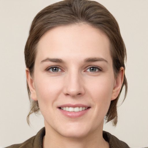 Joyful white young-adult female with medium  brown hair and grey eyes