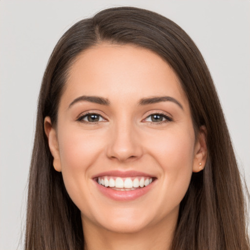 Joyful white young-adult female with long  brown hair and brown eyes