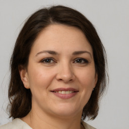 Joyful white adult female with medium  brown hair and brown eyes