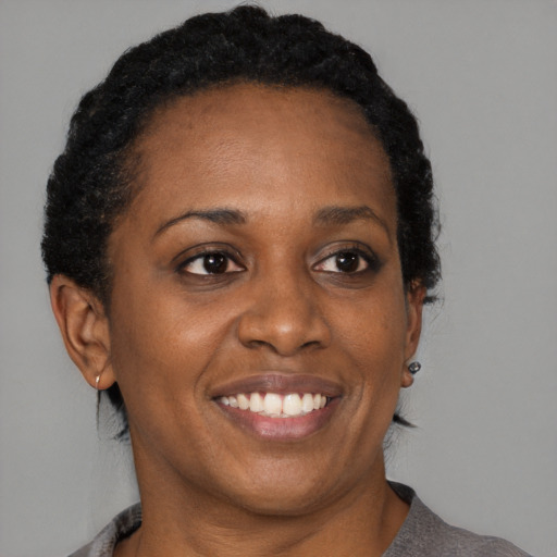 Joyful black adult female with medium  black hair and brown eyes