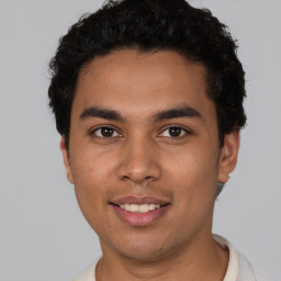 Joyful latino young-adult male with short  brown hair and brown eyes