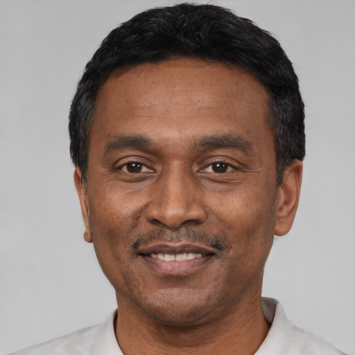 Joyful latino adult male with short  black hair and brown eyes