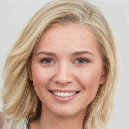 Joyful white young-adult female with long  brown hair and blue eyes