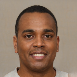 Joyful black young-adult male with short  brown hair and brown eyes