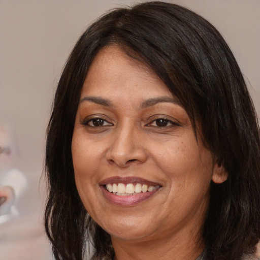 Joyful latino adult female with medium  brown hair and brown eyes