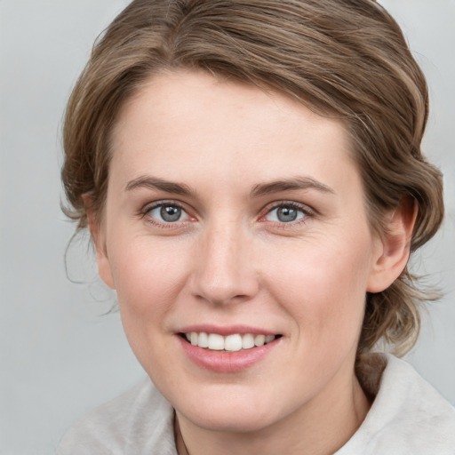 Joyful white young-adult female with medium  brown hair and grey eyes