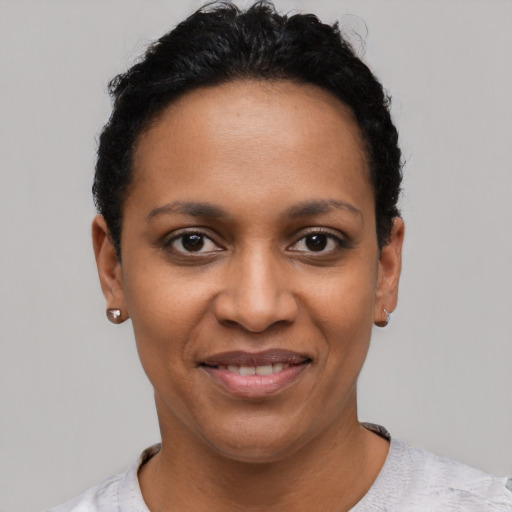 Joyful black young-adult female with short  black hair and brown eyes