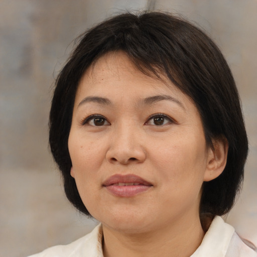 Joyful asian adult female with medium  brown hair and brown eyes