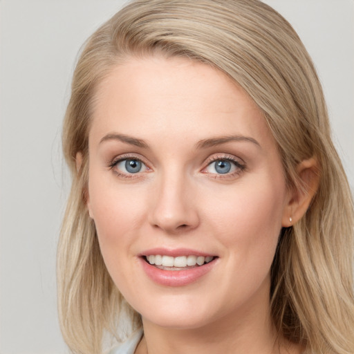 Joyful white young-adult female with long  brown hair and blue eyes