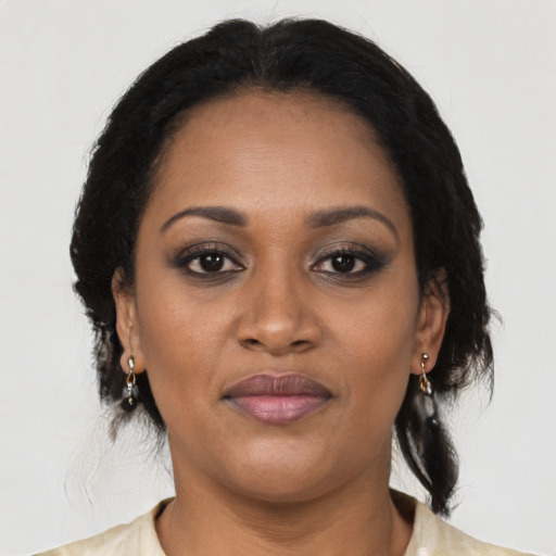Joyful black young-adult female with long  black hair and brown eyes