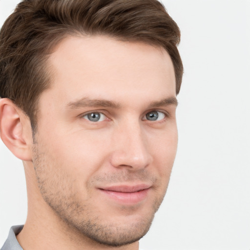 Joyful white young-adult male with short  brown hair and grey eyes