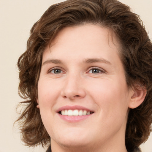 Joyful white young-adult female with medium  brown hair and green eyes