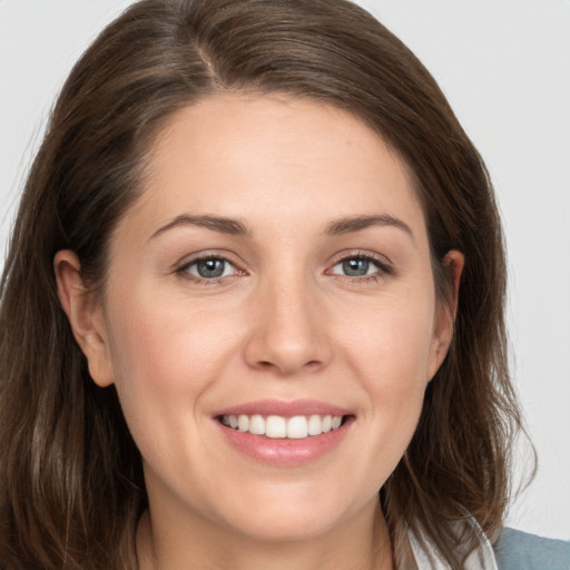 Joyful white young-adult female with medium  brown hair and grey eyes