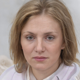 Joyful white adult female with medium  brown hair and blue eyes