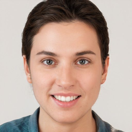 Joyful white young-adult female with short  brown hair and grey eyes