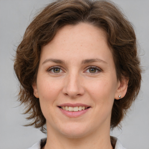 Joyful white young-adult female with medium  brown hair and green eyes