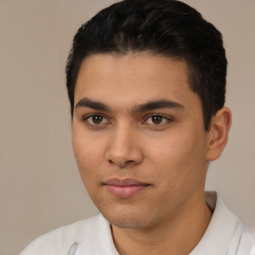 Joyful latino young-adult male with short  black hair and brown eyes