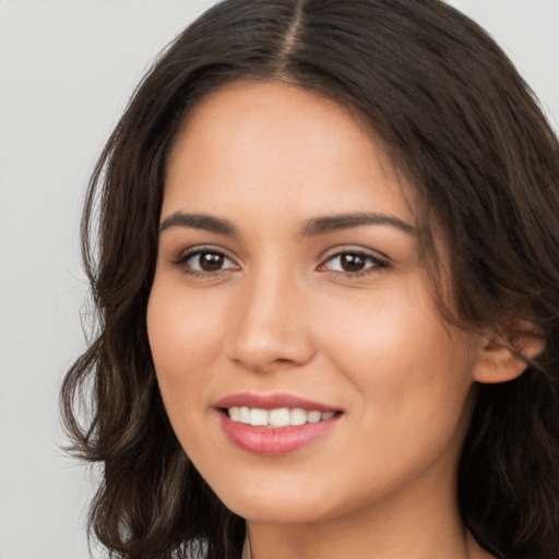 Joyful white young-adult female with long  brown hair and brown eyes