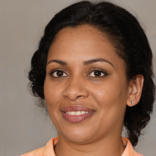 Joyful black young-adult female with medium  brown hair and brown eyes
