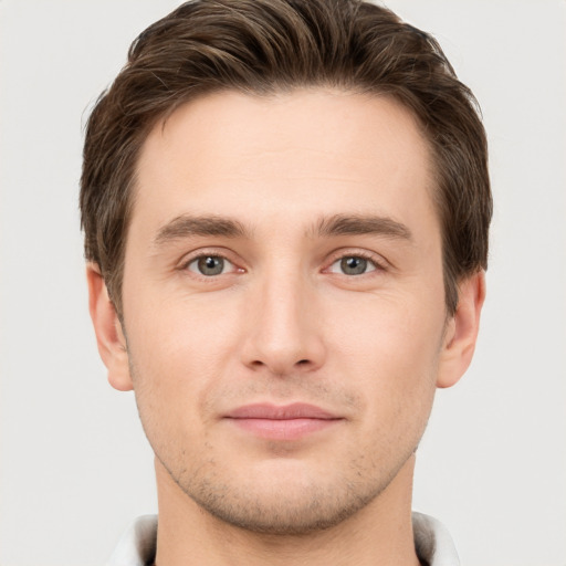 Joyful white young-adult male with short  brown hair and grey eyes