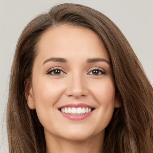 Joyful white young-adult female with long  brown hair and brown eyes