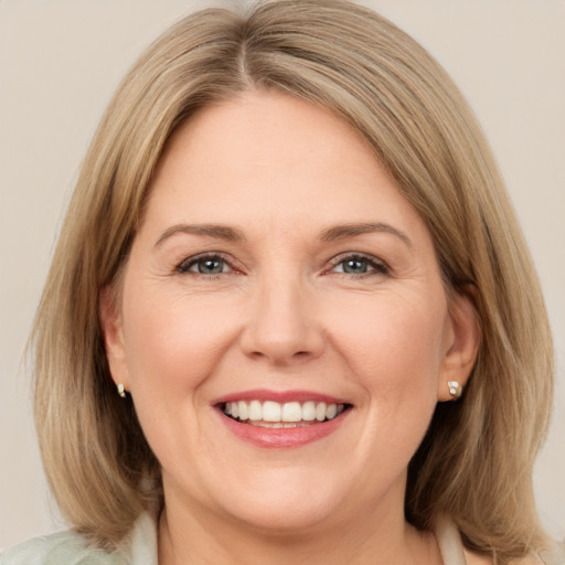 Joyful white adult female with medium  brown hair and green eyes