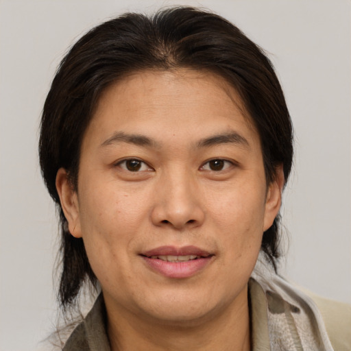 Joyful asian adult female with medium  brown hair and brown eyes