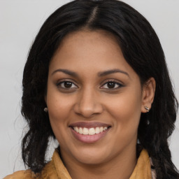 Joyful latino young-adult female with long  brown hair and brown eyes