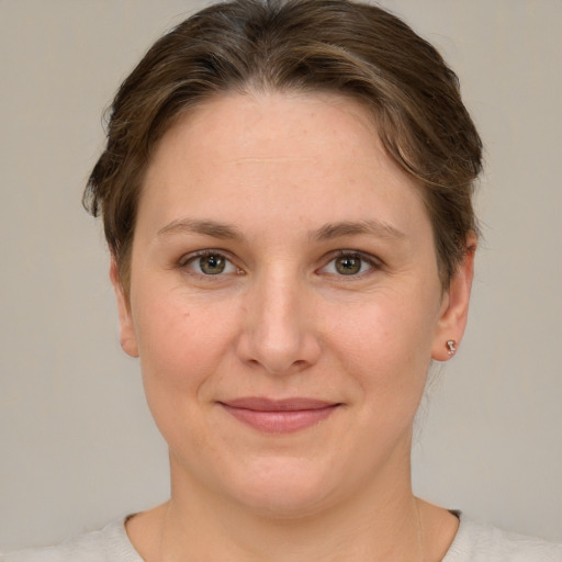 Joyful white young-adult female with short  brown hair and green eyes