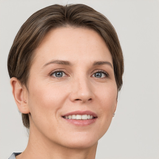 Joyful white young-adult female with short  brown hair and grey eyes