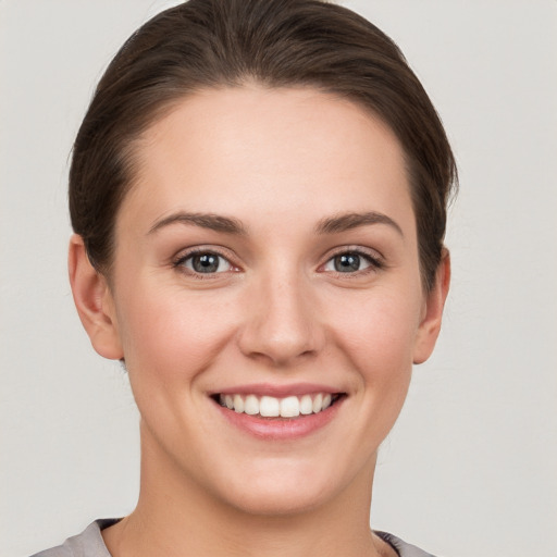 Joyful white young-adult female with short  brown hair and grey eyes