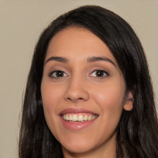 Joyful white young-adult female with long  black hair and brown eyes