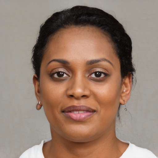 Joyful black young-adult female with short  black hair and brown eyes