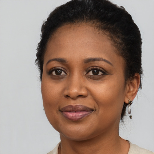 Joyful black adult female with medium  black hair and brown eyes