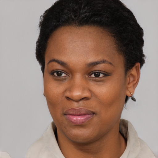 Joyful black young-adult female with short  black hair and brown eyes