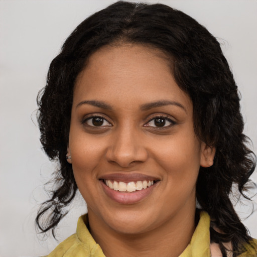 Joyful black young-adult female with long  brown hair and brown eyes