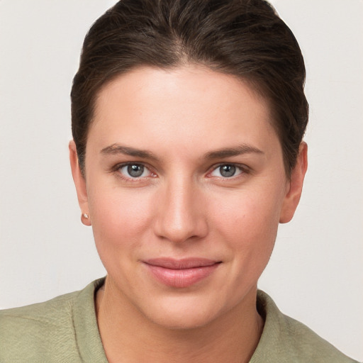 Joyful white young-adult female with short  brown hair and grey eyes