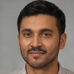 Joyful latino young-adult male with short  black hair and brown eyes