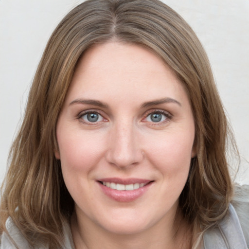 Joyful white young-adult female with medium  brown hair and blue eyes