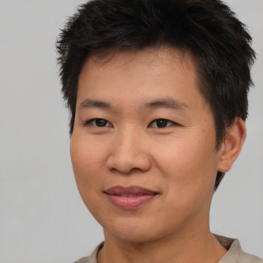 Joyful asian young-adult male with short  brown hair and brown eyes
