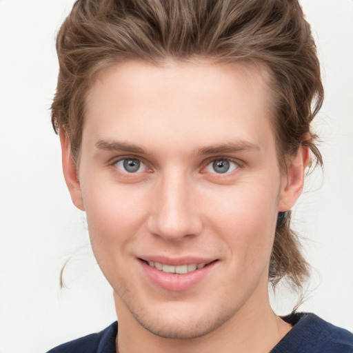 Joyful white young-adult male with short  brown hair and grey eyes