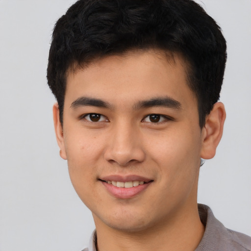 Joyful asian young-adult male with short  brown hair and brown eyes