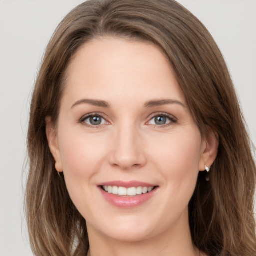 Joyful white young-adult female with long  brown hair and grey eyes