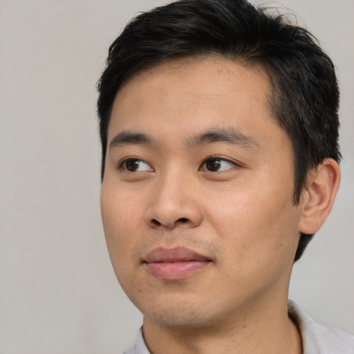 Joyful asian young-adult male with short  brown hair and brown eyes